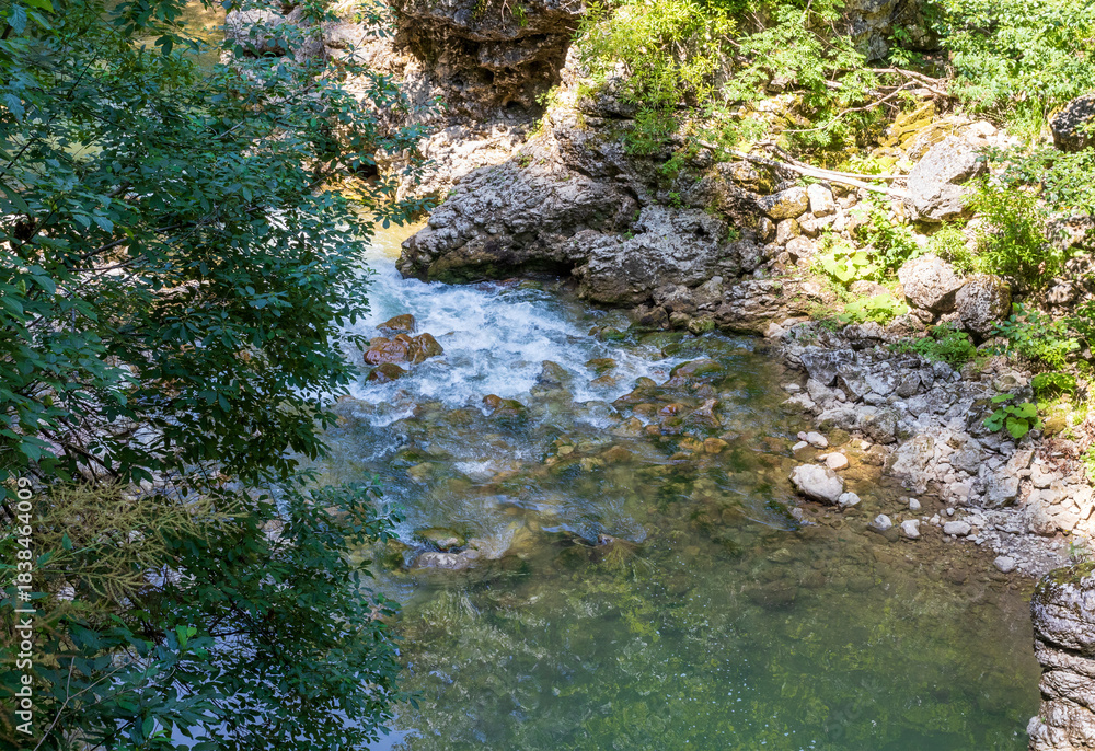Obraz premium a mountain river with a rapid flow and an unusual stone bed and waterfalls in the summer