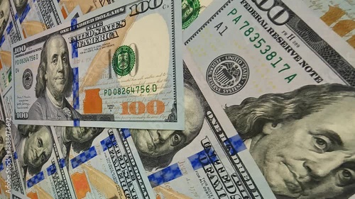 Continuous slide across scattered 100 dollar banknotes forming an exclusive financial business setting that emphasizes investment depth and the vibrant movement of cash and money