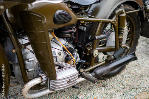 Dniepr motorcycle engine with boxer cylinder, components and exhaust system photographed from the side on gravel surface