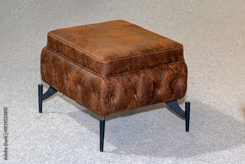 Brown leather material seat with metal legs isolated on room interior floor