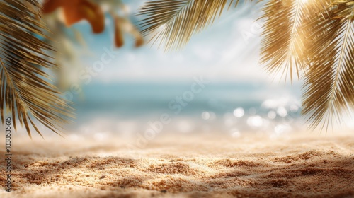 Palm trees frame a sandy beach scene under bright sunlight. Gentle waves lap at the shoreline creating a tropical atmosphere. The sky is clear and blue.