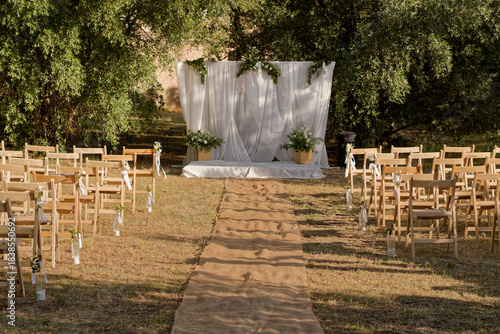 Outdoor wedding ceremony setup with rustic chairs