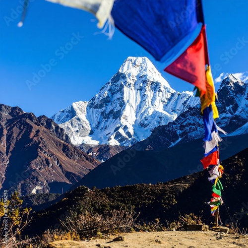 Snowy mountain peak framed by colorful prayer flags against a vibrant blue sky