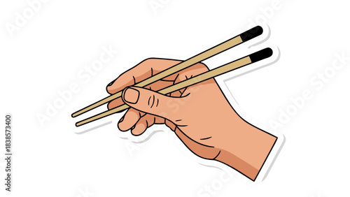 A human hand holding a pair of wooden chopsticks against a black background a close up detail of the fingers gripping the utensil and ready to pick up food preparation for a meal dining accessory and