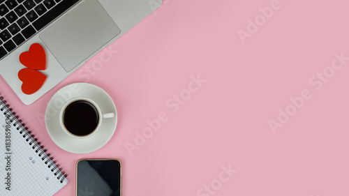 pink workspace with devices and floral accents, creative freelancer enjoying holiday with cozy desk setup