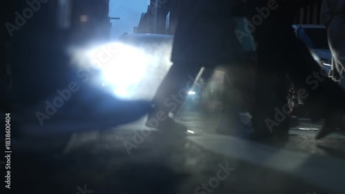 Slow motion low angle view showing pedestrians crossing street in New York City, USA. Cold winter street scene with people waking in NYC.