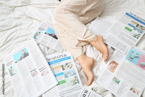 Legs of woman with newspape...