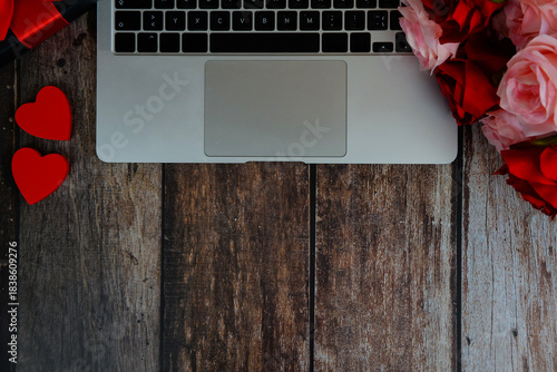 laptop with hearts and roses on a wooden background with space for text, happy valentine's day