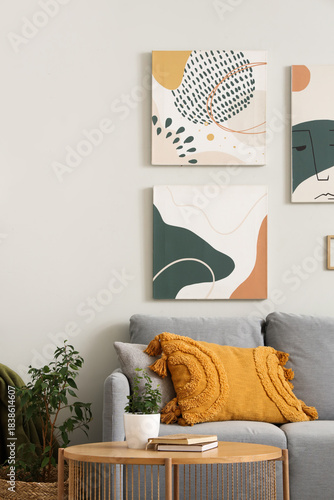Cozy sofa with modern pictures and coffee table in living room