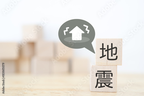 地震の木ブロックと揺れる住宅イラストによる防災イメージ。
