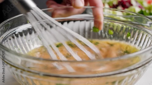 Whisking a Delicious Salad Dressing in a Clear Glass Bowl.