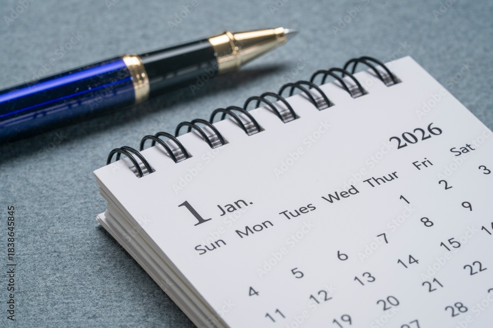 Naklejka premium January 2026 - small spiral desktop calendar with a pen, time and business concept