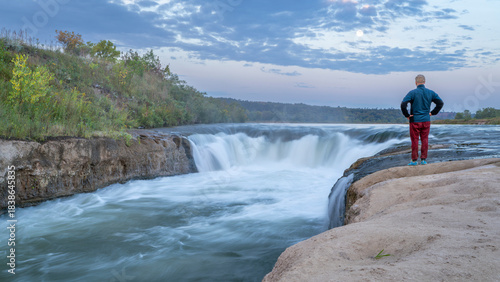 lonely man contemplating the Norden Chute on Niobrara River in Nebraska, late summer sunrise  scenery
