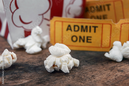Popcorn and movie tickets on a wooden background