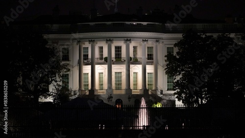 Lights shine on the Whitehouse and its surroundings at night in Washington DC while people visit and take pictures