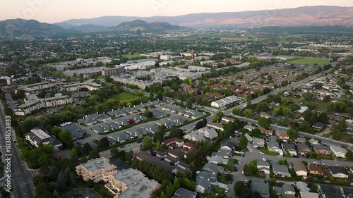 Aerial view of a non-descriptive city showing residential and low-rise buildings of a suburban setting with mountains in the background
