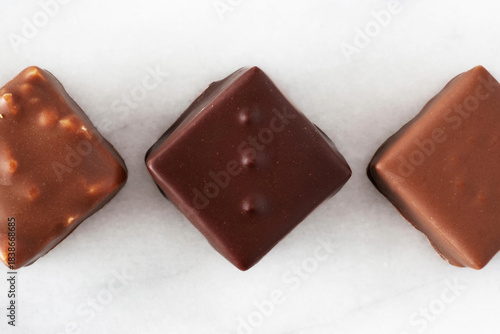 Assortment of chocolates lined up on a white background
