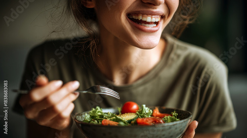 Radiant smile complements a vibrant salad, showcasing health and wellness through mindful nourishment.