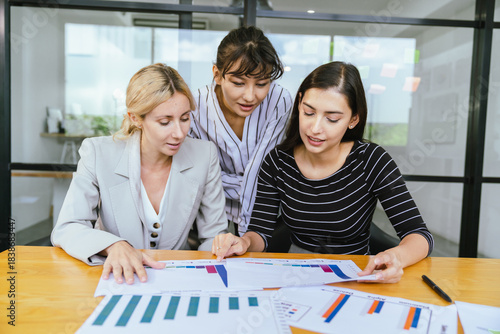 Business team analyzing data and marketing strategy in modern office, brainstorming ideas for project success using laptops and charts, teamwork collaboration for corporate growth