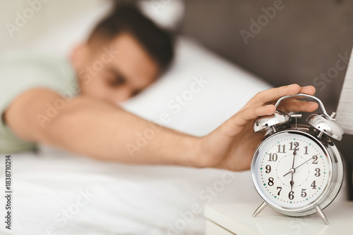 Принти на полотні A man reaches out to turn off his alarm clock early in the morning
