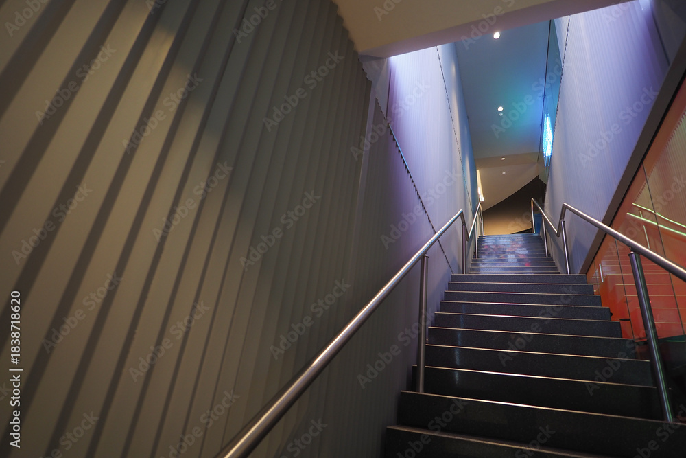 Fototapeta premium Steps lead to upper floor in a building at night