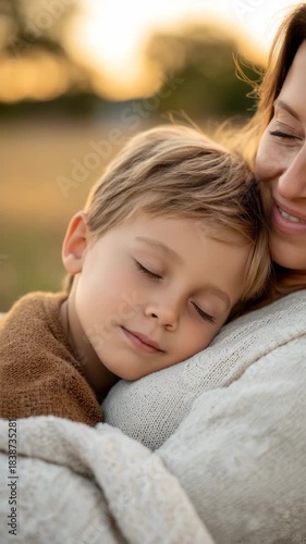 Serene mother and son embrace in sunset field captures peaceful family moment
