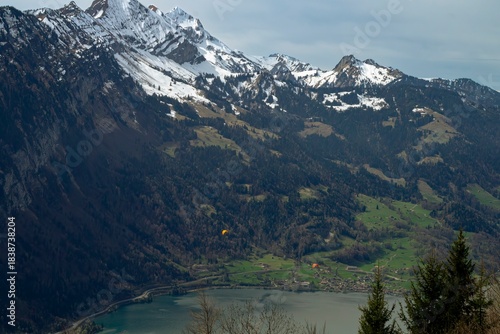 paragliding over lake in swiss alps 