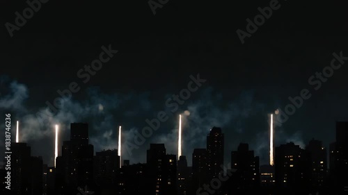 Spectacular fireworks burst above a dark city skyline, creating a dazzling night display