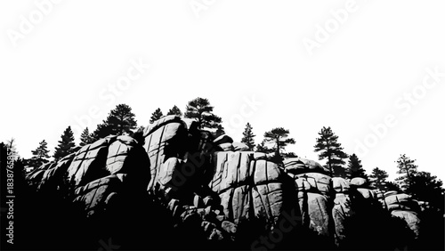 Dramatic black and white image of rocky mountain landscape with trees.
