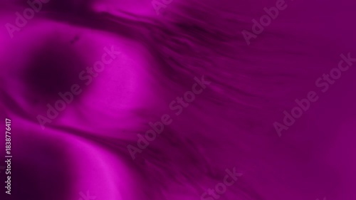 Pouring ink. Blur splatter texture. Defocused neon purple color water dark black liquid fluid spreading on abstract art background.