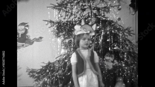 Christmas children celebration. Little girl in fox costume reciting poem, singing on Christmas tree in kindergarten New Year holiday performance. Old film. Archival retro 1960s. Vintage archive