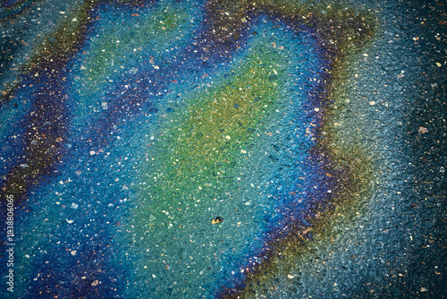 Oil Slick Creates Colorful Patterns on the Ground During Daylight Hours in an Urban Area