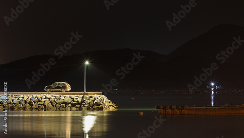 Quiet Night at the Breakwater End with a Lone Streetlight and Parked Car