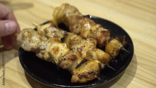 Hand picking grilled chicken skewer Japanese yakitori izakaya drinking food