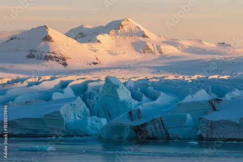 Snow-capped mountains and icebergs in a polar landscape at golden hour