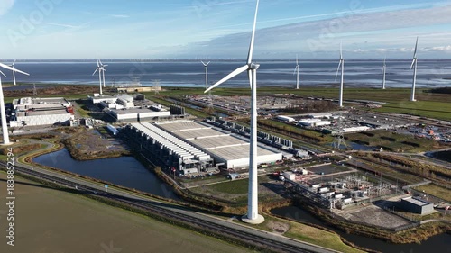Wallpaper Mural Aerial drone video of wind turbines before a large energy consuming data center in Eemshaven, showing the relationship between renewable power generation and modern computing infrastructure. Torontodigital.ca