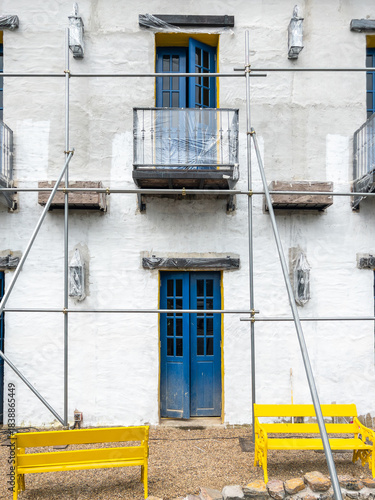 White European Style Building Under Renovation with Scaffolding.
