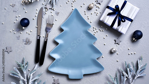 Festive christmas table setting with tree shaped plate and gift