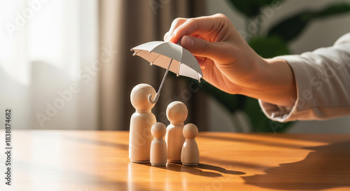 Conceptual image of wooden peg family receiving protection under a small umbrella representing health coverage and life insurance.