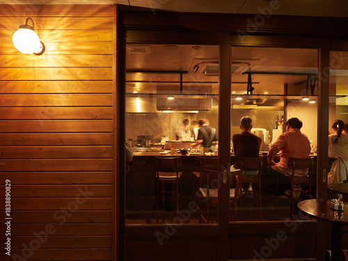 観光名所高山の古い町並みの夜の飲食店の店内で食事する観光客の姿