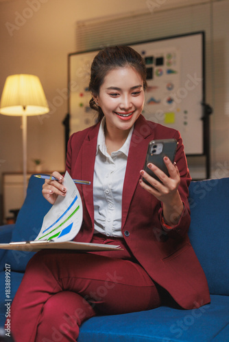 Woman smiling using smartphone for remote business meeting