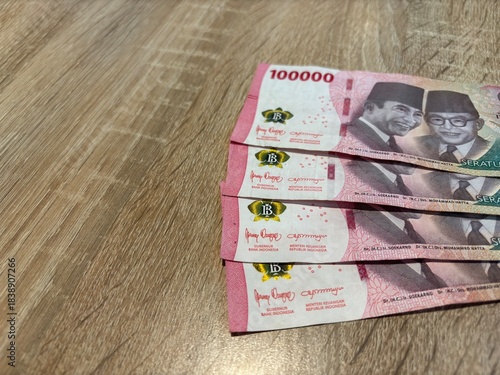 Close up of Indonesian Rupiah 100000 banknotes on wooden background