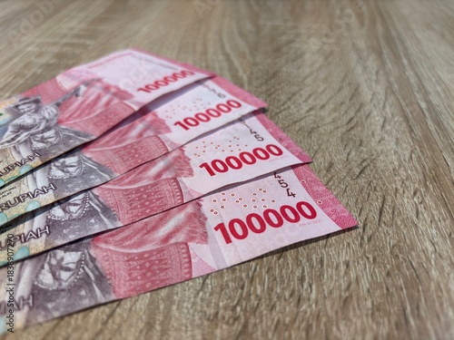 Close up of Indonesian Rupiah 100000 banknotes on wooden background