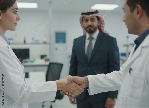 Professional handshake between healthcare professionals and a business executive in a modern medical laboratory setting