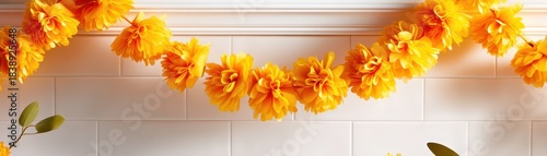 Vibrant yellow flower garland hanging elegantly over a white background.