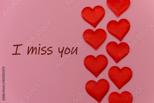 Wallpaper Mural A pink background with the text 'I miss you' in brown. Seven red fabric hearts are arranged vertically beside the text. Torontodigital.ca