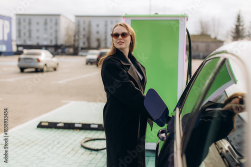Woman charging electric car at public station