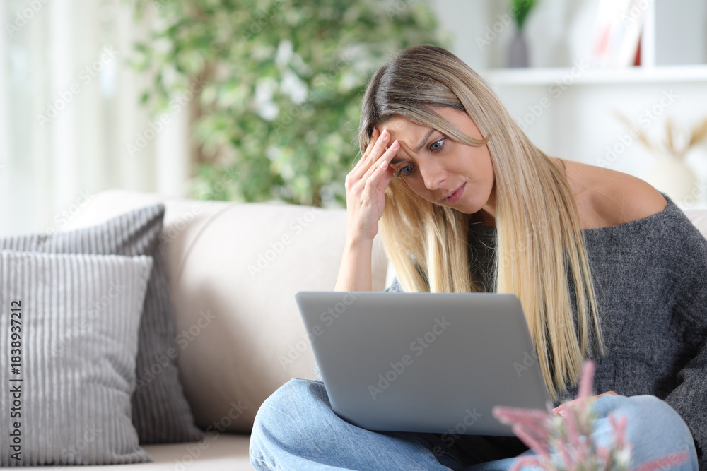 Naklejka premium Angry and worried woman checking laptop at home