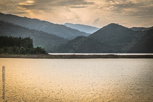 Golden light over tranquil mountain lake reservoir landscape