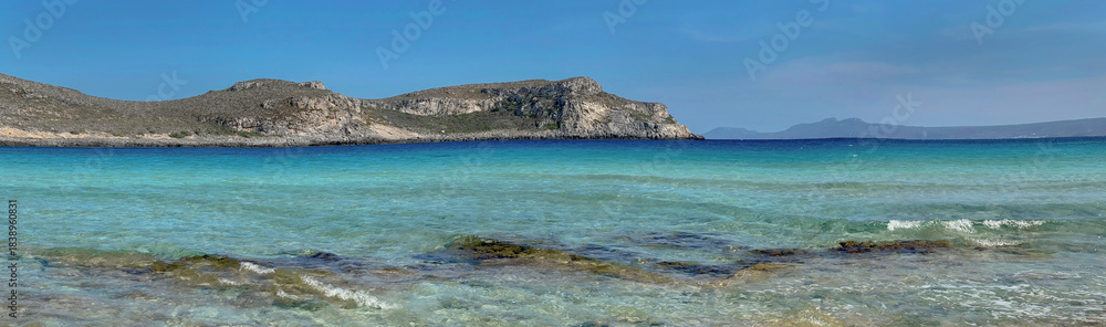 Fototapeta premium beautiful turquoise blue sea in Simos beach with sandy hill background in the island Elafonisos in peloponnese, greece